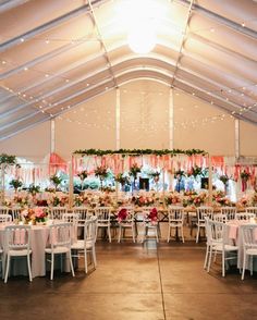 the inside of a tent with tables and chairs set up for a wedding or other function