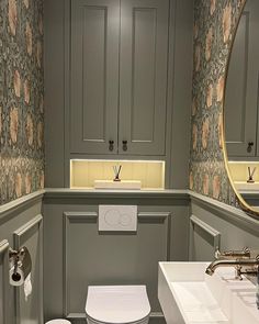 a bathroom with two sinks, a toilet and a mirror above the sink in it