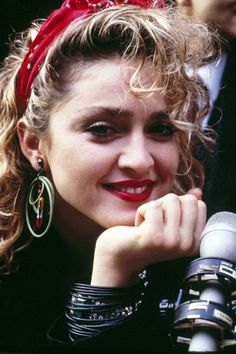 a close up of a person with a microphone in front of her face and wearing ear rings