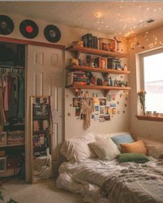 a bed sitting under a window next to a book shelf filled with lots of books