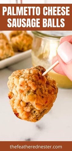 a hand holding up a cheesy sausage ball in front of some other food