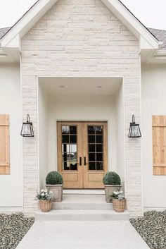 the front door to a home with two potted plants on each side and an instagram button that says visit