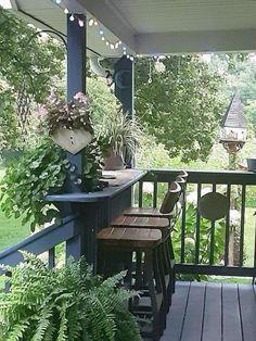 the porch is covered with plants and potted plants