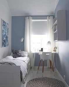 a bedroom with blue walls and white furniture