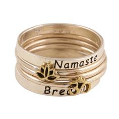 Two broad sterling silver bands inscribed with the words namaste and breathe cradle three narrower sterling silver rings in this original design by India's Shivani Choudhary. One of the narrow bands features a raised brass lotus the second features a raised brass om symbol and the third complements the other two with its simplicity. The words and symbols are oxidized to further highlight the motifs. Spiritual Personalized Jewelry For Promise, Personalized Spiritual Jewelry For Promise, Spiritual Personalized Jewelry For Promises, Nickel-free Spiritual Jewelry For Promise, Meaningful Silver Stackable Jewelry, Symbolic Adjustable Stackable Rings For Anniversary, Adjustable Spiritual Stackable Rings As Gift, Symbolic Stackable Adjustable Jewelry, Spiritual Stackable Promise Jewelry