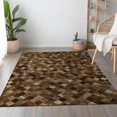 a living room area with a rug, chair and potted plant