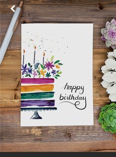 an image of a birthday card with flowers and cake on the table next to it