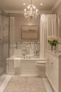 a bathroom with a chandelier, toilet and bathtub