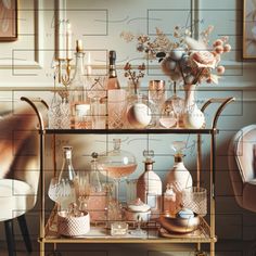 an assortment of vases and bottles on a gold cart in front of a wall