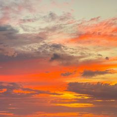 an airplane is flying in the sky at sunset with clouds and sun setting behind it