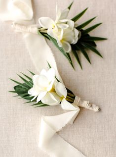 two white flowers are sitting on top of each other next to a piece of cloth