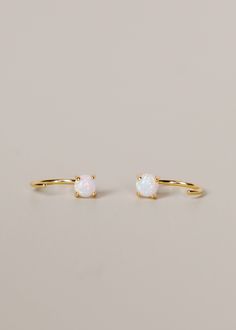 Made for joyful energy, our dainty Opal Huggies will stand out from the rest and are perfect for everyday wear. Loop these through and let this pair "hug" your ears tight for a constant reminder of what the beautiful gemstone represents. Featuring a petite polished synthetic Opal stone cut into shape and set in an 18k gold-plated prong earring over sterling silver, also known as 'vermeil.' Handmade. Nickel, lead, and brass-free. Description provided about crystals and stones is for information p Elegant Adjustable Hypoallergenic Huggie Earrings, Adjustable Yellow Gold Huggie Earrings, Ear Huggies, Synthetic Opal, Everyday Accessories, Huggie Earrings, Opal Stone, Sterling Silver Hoops, Stone Cuts