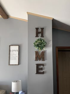 a living room wall with the word home spelled in wood letters and flowers on it