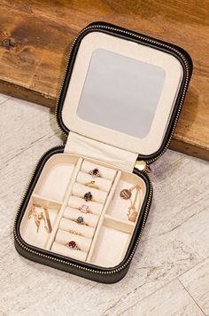 an open jewelry box sitting on top of a wooden floor