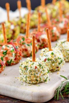 appetizers are arranged on a cutting board with toothpicks sticking out of them