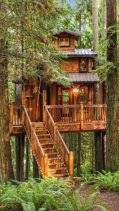 a tree house in the woods with stairs leading up to it's second story