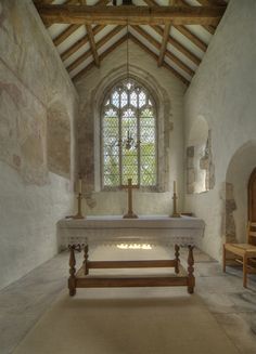 an old church with a stone alter and stained glass window