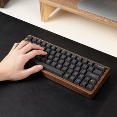 a person is typing on a wooden keyboard