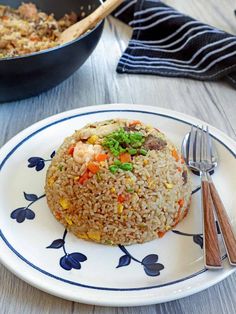 a white plate topped with fried rice and vegetables