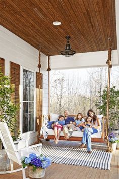 a group of people sitting on a porch swing