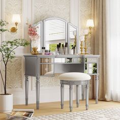 a vanity table with stool and mirror in a living room next to a vase filled with flowers