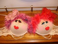 two masks with pink and red hair are sitting on a table