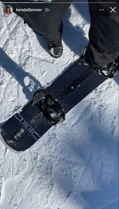 the snowboarder is standing in the snow with his feet propped up on it