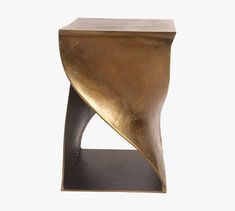 a gold and black side table with an irregular design on the top, against a white background