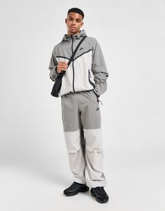 Street-ready style lands from the Swoosh with these men's Tech Woven Oversized Track Pants from Nike. In a Flat Pewter and Light Iron Ore colour block design, these roomy pants are cut from lightweight stretch-woven fabric that helps wick sweat from the skin. They feature articulated knees for extra movement and an elastic waistband with a bungee drawcord to secure them in place. With different sized Tech tape pockets for your essentials, they're finsihed off with the signature Nike Futura logo. Machine washable. | Our model is 6'1" with a 39" chest and wears a size medium. Oversized Track Pants, Grey Nike Tech, Gym Tights, Retro Football Shirts, Iron Ore, Dodgers Baseball, Adidas Originals Superstar, Football Training, Latest T Shirt