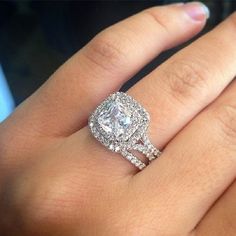 a woman's hand with a diamond ring on top of her finger and the engagement band