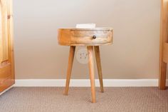 a small wooden table sitting on top of a carpeted floor