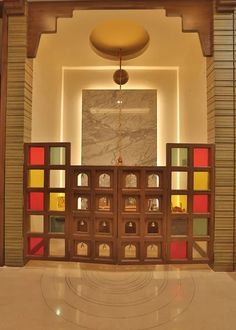 an entrance to a building with stained glass and wood panels on the walls, along with a circular light fixture hanging from the ceiling