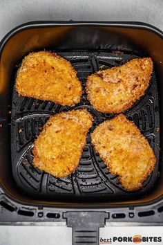 four pieces of fried chicken cooking in an air fryer