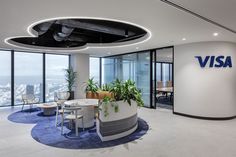 an office with large windows and plants in the center