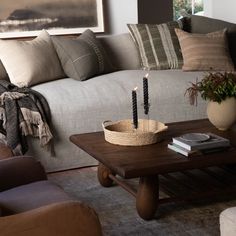 a living room filled with furniture and pillows on top of a wooden table in front of a couch