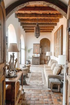 a living room filled with lots of furniture next to a doorway that leads into another room