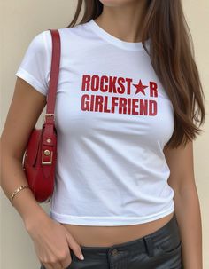 Rockstar Girlfriend Baby Tee ✰ Unleash your inner rockstar with our "Rockstar Girlfriend" baby tee! Whether you're a rockstar, dating one, or simply love the rock 'n' roll vibe, this tee is your next go to. Designed to capture the effortless 90s rockstar girlfriend aesthetic, this statement tee is perfect for concerts, music festivals, or just adding a rockstar vibe to your everyday look. Key Features: Effortless 90s Vibe: Embrace the nostalgic 90s and Y2K fashion with this cool girl staple. Ver Hot Rockstar Girlfriend Outfits, Fitted Y2k Style T-shirt For Concert, Edgy Letter Print Tops For Music Festivals, Y2k Graphic Print Tops For Music Festival, Y2k Style Short Sleeve T-shirt For Concerts, Rockstar Lifestyle, Y2k Graffiti Print Tops For Concert, Y2k Letter Print Top For Concerts, Grunge Text Print Top For Concerts