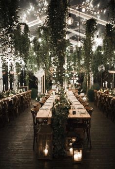 a long table is set up with candles and greenery for an outdoor wedding reception