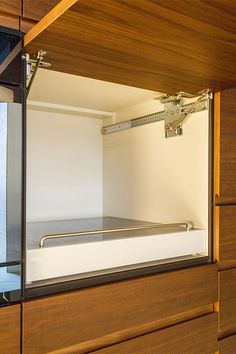 an empty bed is in the corner of a room with wood paneling and glass doors