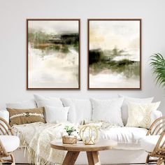 two paintings hanging on the wall above a white couch