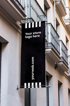 a black and white sign hanging from the side of a building next to balconies