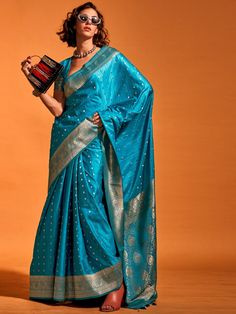 Wear this designer saree in a stunning sky-blue color, made from luxurious silk material, adorned with exquisite zari weaving work and attached tassels. This adorable sky-blue zari-weaving satin wedding wear saree is perfect for creating fashion statements at festivals, weddings, and events.
The set includes a blouse made from the same color silk material with zari weaving work. The saree measures 5.50 meters, allowing for versatile draping styles, and the blouse material is unstitched, providin Blue Silk Blouse Designs, Blue Silk Blouse, Satin Silk Saree, Handloom Weaving, Party Sarees, Teal Blue Color, Ready To Wear Saree, Satin Saree, Party Kleidung