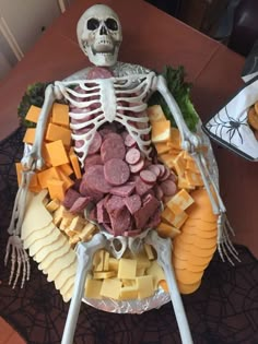 a skeleton made out of cheese and meats on a plate with other food items