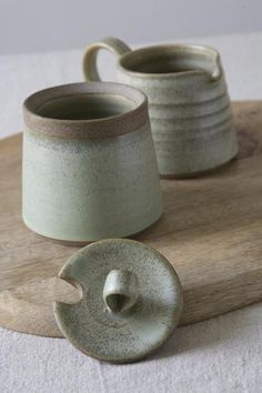 two mugs sitting on top of a wooden board