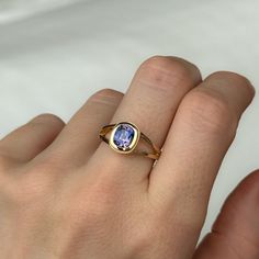 a woman's hand with a ring on it that has a blue stone in the middle