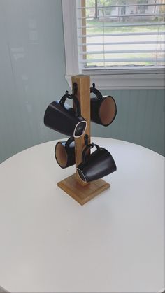 three black lights on a wooden stand on a white table