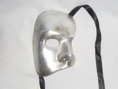 Hand made silver Phantom of the Opera mask. The mask has black satin ribbons for wearing.   Mask is 5 inches wide and 7 inches high.  Imported from Venice, Italy.   This mask is made out of paper  mache. Silver Theater Mask For Carnival, Silver Masks And Prosthetics For Theater And Carnival, Silver Mask For Costume Party, Silver Masks For Costume Party, Silver Formal Masquerade Mask For Carnival, Silver Eye Mask For Theater, Silver Masks For Theater And Carnival, Elegant Silver Masks And Prosthetics For Costume, Silver Venetian Mask For Theater