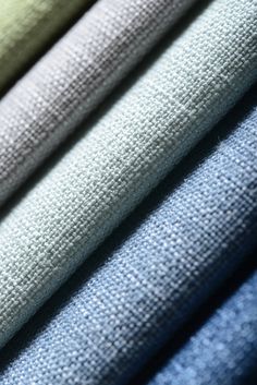 several different colors of fabric on top of each other, including blue and greys