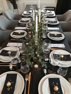 the table is set with black and gold place settings