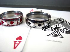 two wedding rings sitting on top of playing cards